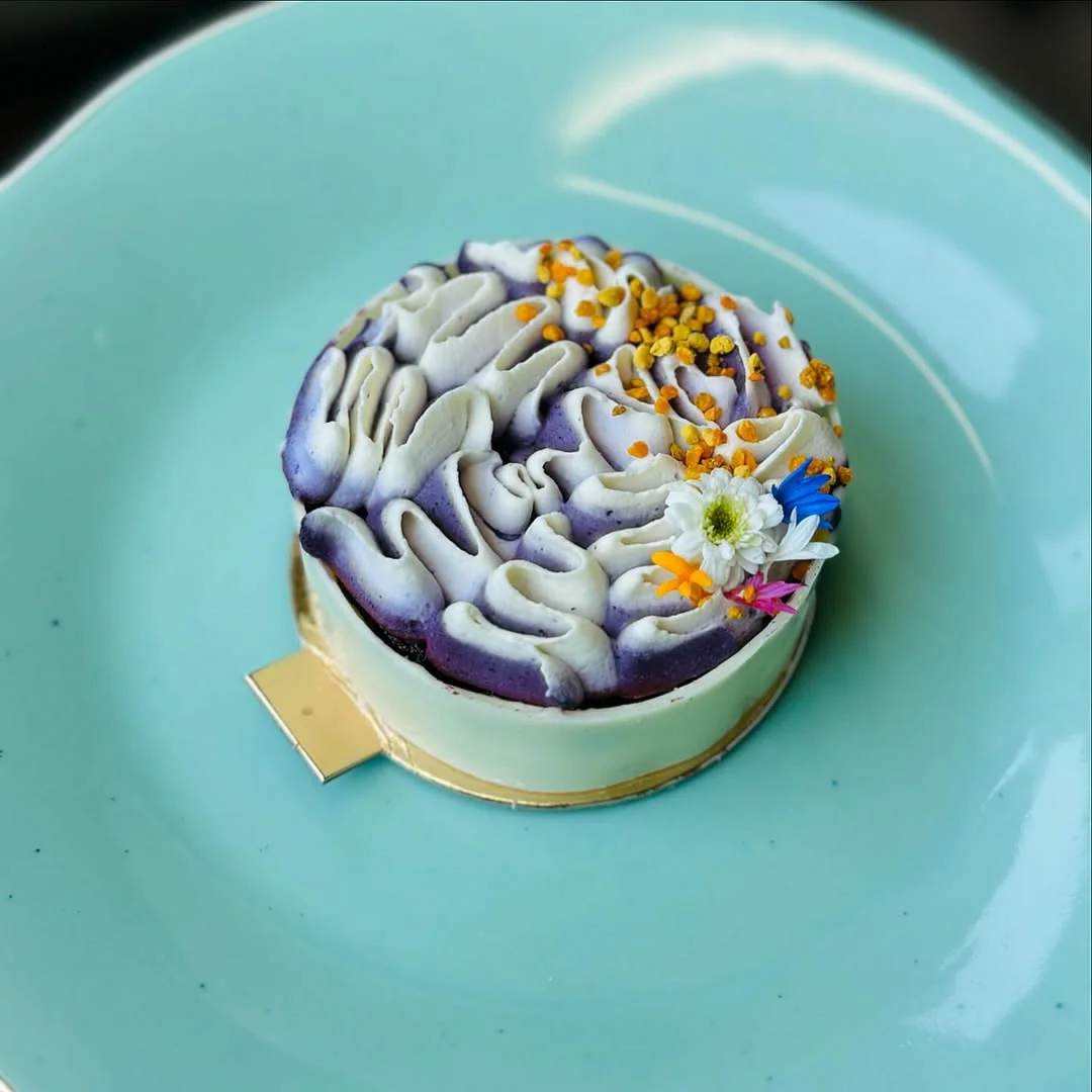 Ube, Honey & Bee Pollen — purple-yam crown over white-chocolate ganache finished with bee pollen and edible flora